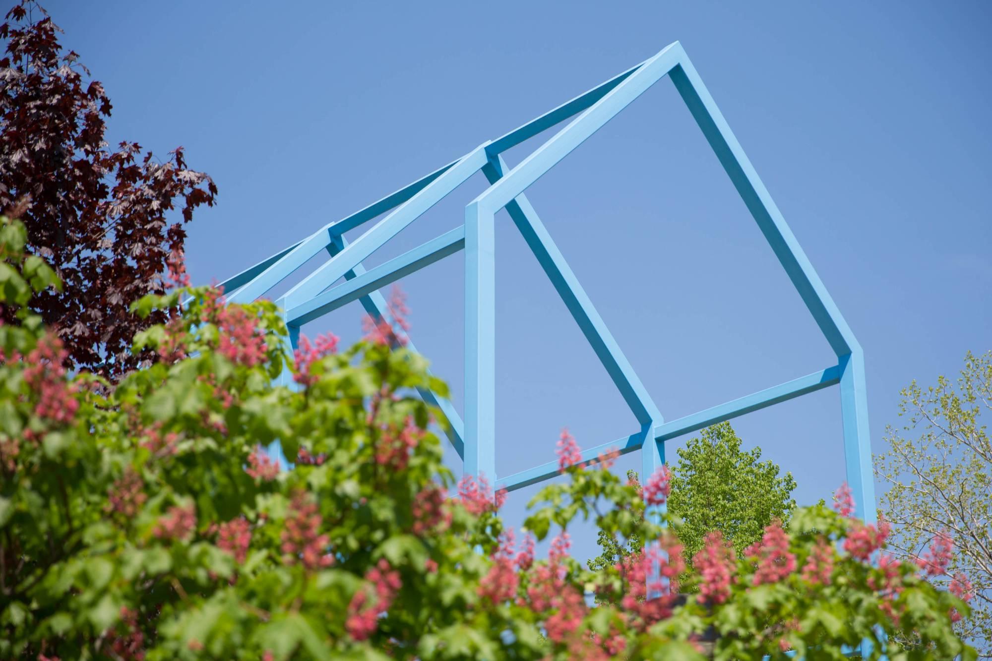 Blue sculpture with greenery in foreground